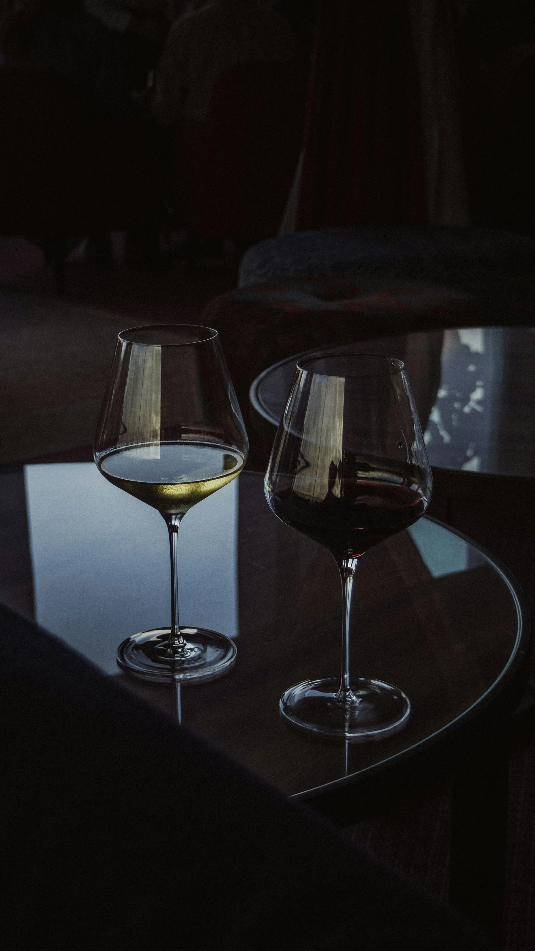 Two wine glasses on a softly lit table